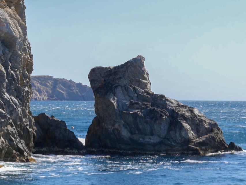 Cap Norfeu: Costa Brava Catamaran Trip with Underwater Views - Leaving Roses with the port, lighthouse, and castle in view