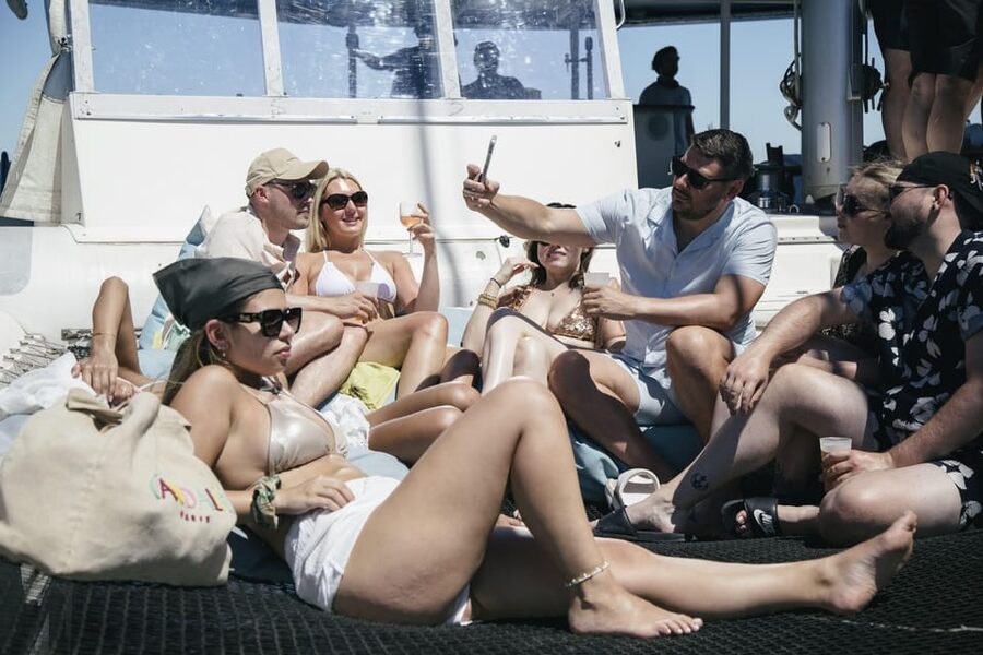 Lisbon: Catamaran Boat Party with Music, Open Bar & Dives - Passing beneath the 25 de Abril Bridge