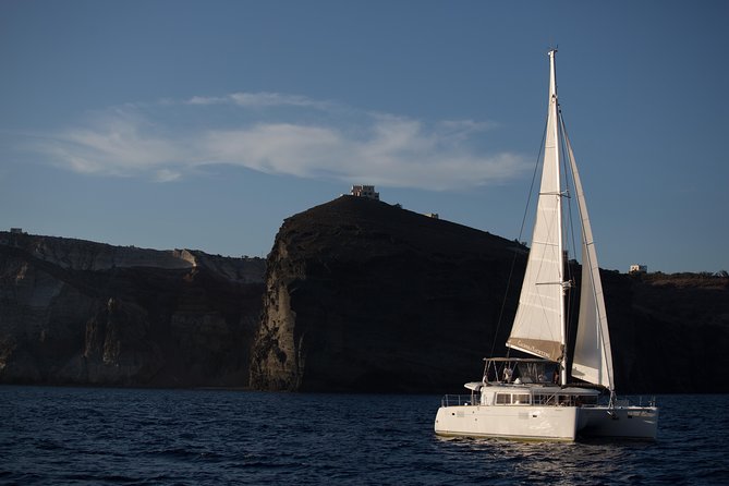 Santorini:All-inclusive Catamaran Cruise with Thirassia Stop - White Beach, the lighthouse, and Black Mountain