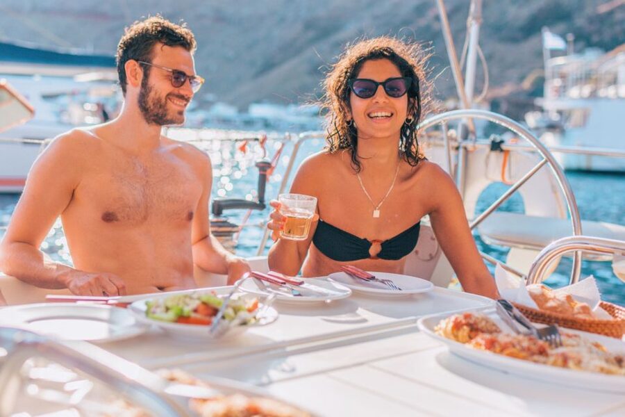 Santorini Caldera: Sunset Sailing Cruise with Meal - Opening the sails inside the caldera