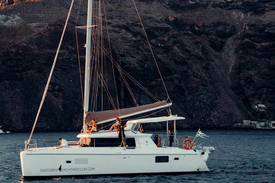 Santorini: Catamaran Caldera Cruise with Meal and Drinks - Leaving Ammoudi Bay beneath the caldera