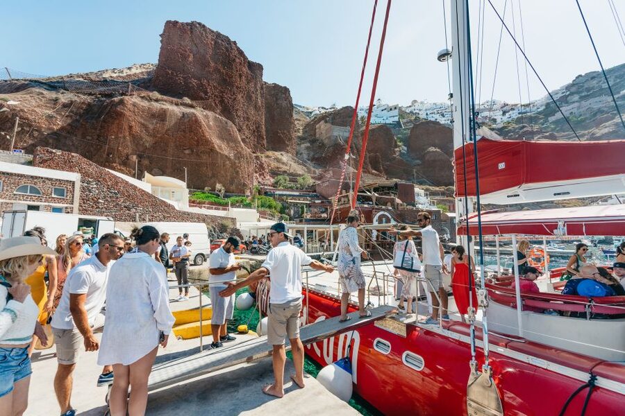 Santorini: Catamaran Tour with BBQ Dinner, Drinks, and Music - White Beach and the caldera cliffs