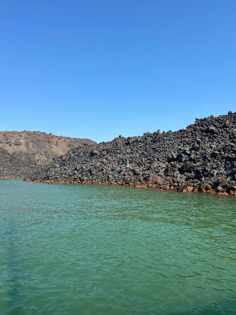 Santorini:Cruises with Catamaran around the Volcanic Island. - White Beach, the lighthouse, and Black Mountain