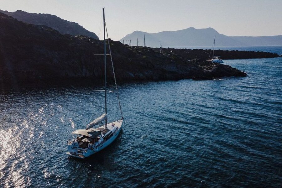 Santorini: Private Caldera Sailing Trip with Open Bar & Meal - Entering the caldera below the lighthouse