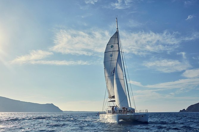 Santorini Sunset Luxury Sailing Catamaran Cruise with BBQ, drinks, transfer - Sailing past the lighthouse, volcano, and Palea Kameni